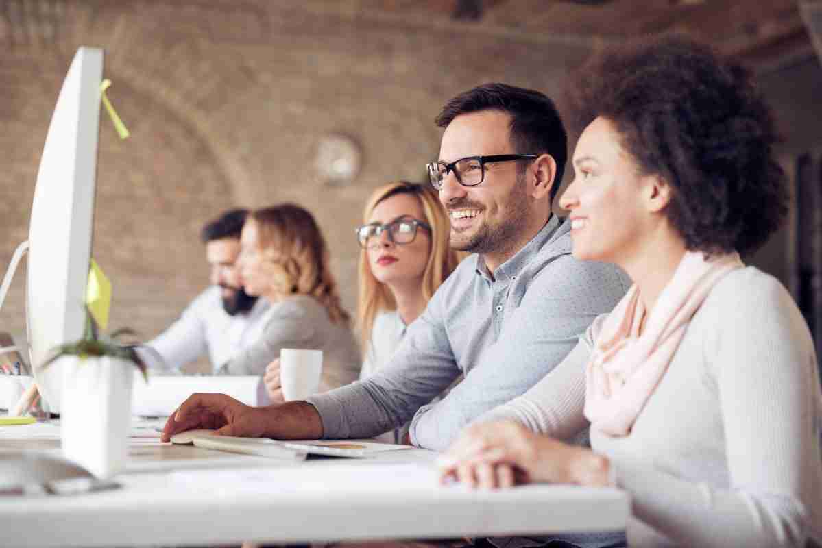 Diverse young co-workers collaborating at a computer