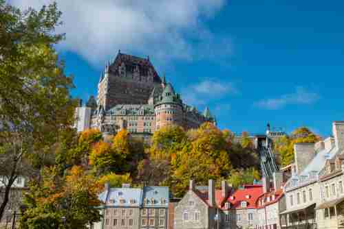 A panoramic view with some of the Old City of Quebec City in the foreground with the iconic Chateau Frontenac above.