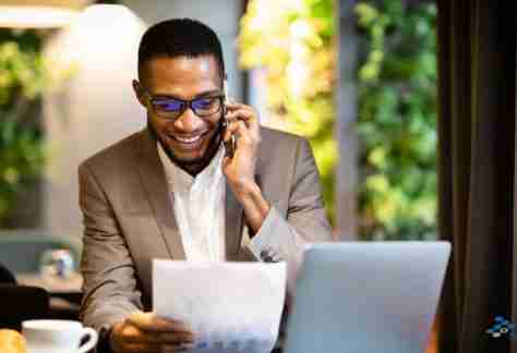 Man talking on a mobile phone and using his computer.
