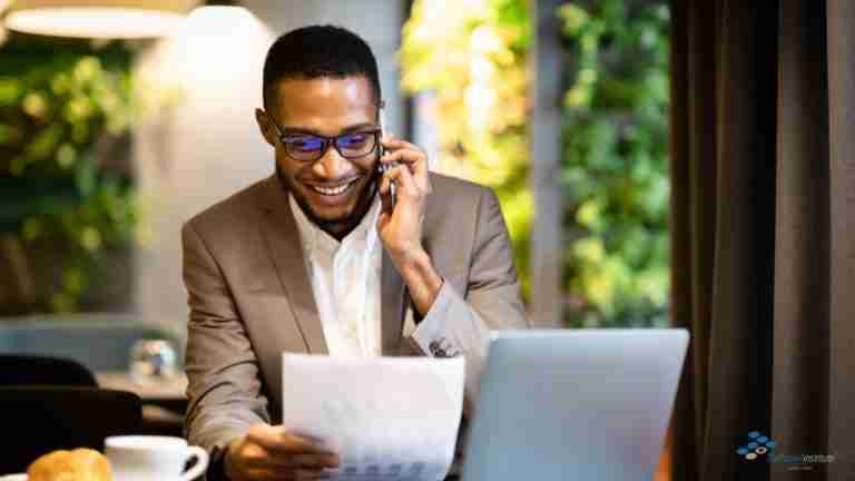 Man talking on a mobile phone and using his computer.
