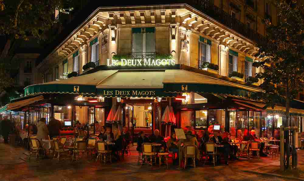 Exterior of the famous Les Deux Magots cafe in Paris at night - Petr Kovalenkov/Shutterstock.com