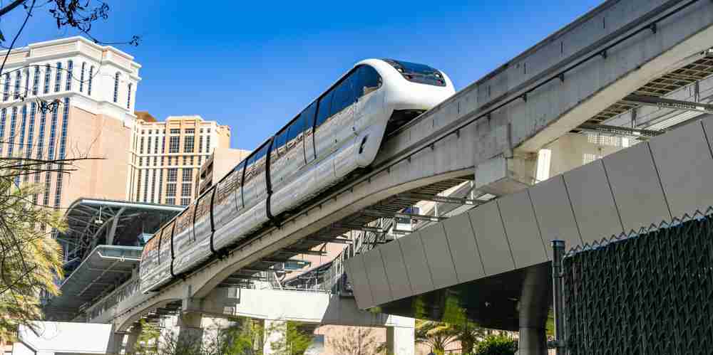 The Las Vegas Monorail leaving a station as seen from below on a sunny day.