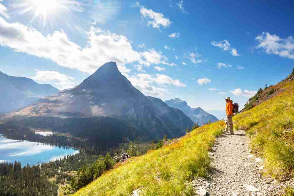 Hiker on a path at a lookout in Glacier National Park in Montana