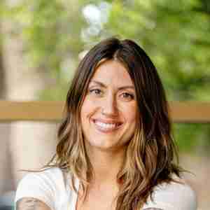 Stephanie Samson headshot. Woman with long brown hair and white shirt smiling.
