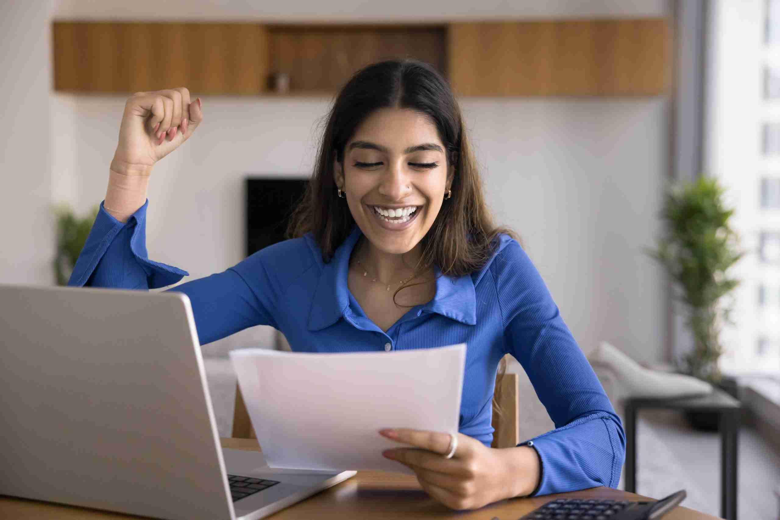 Woman celebrating after getting answers correct on her paper.