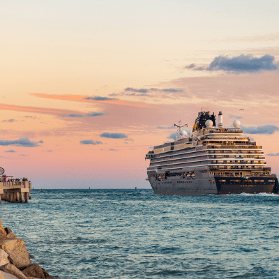 Sunset sky with large cruise ship on the water.
