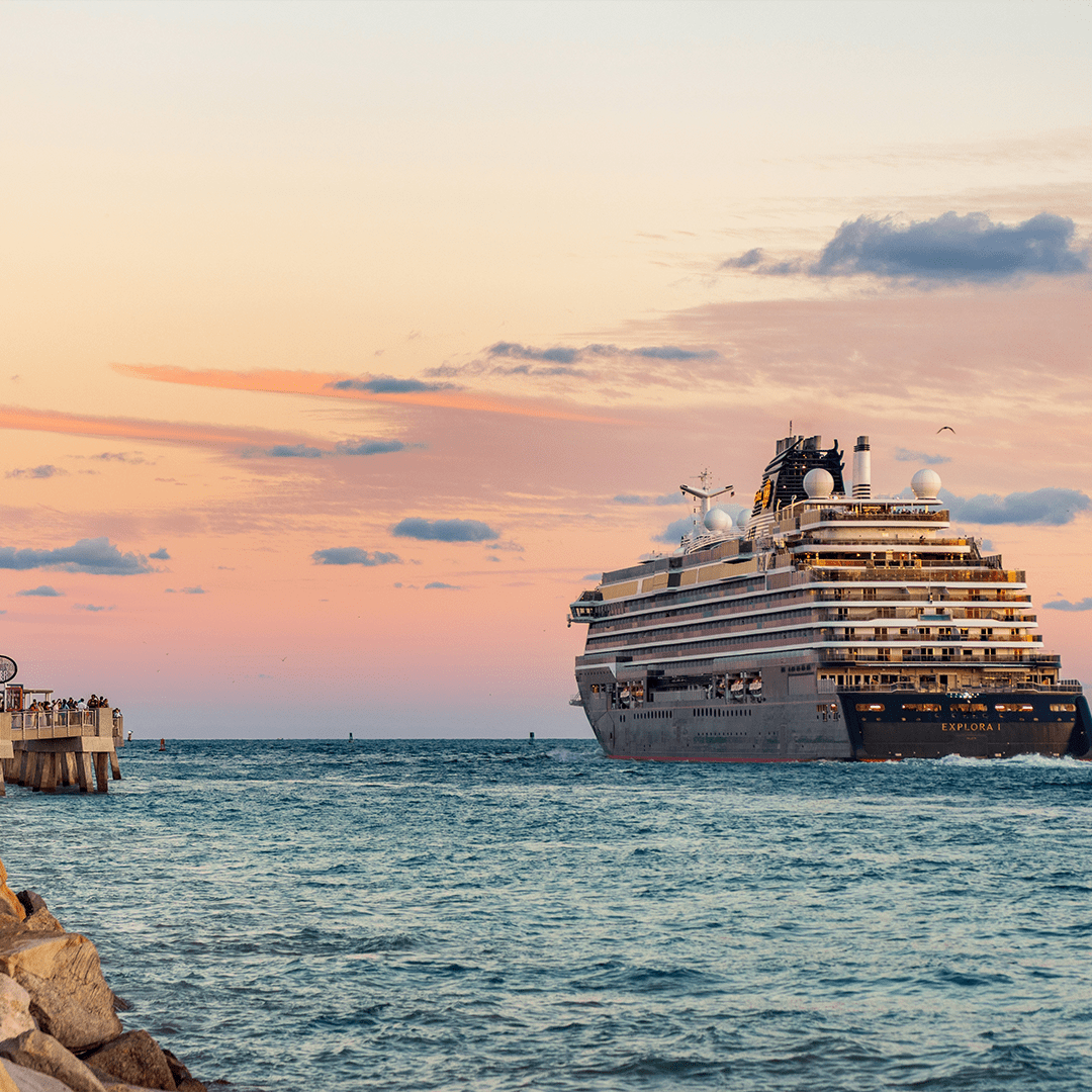 Sunset sky with large cruise ship on the water.