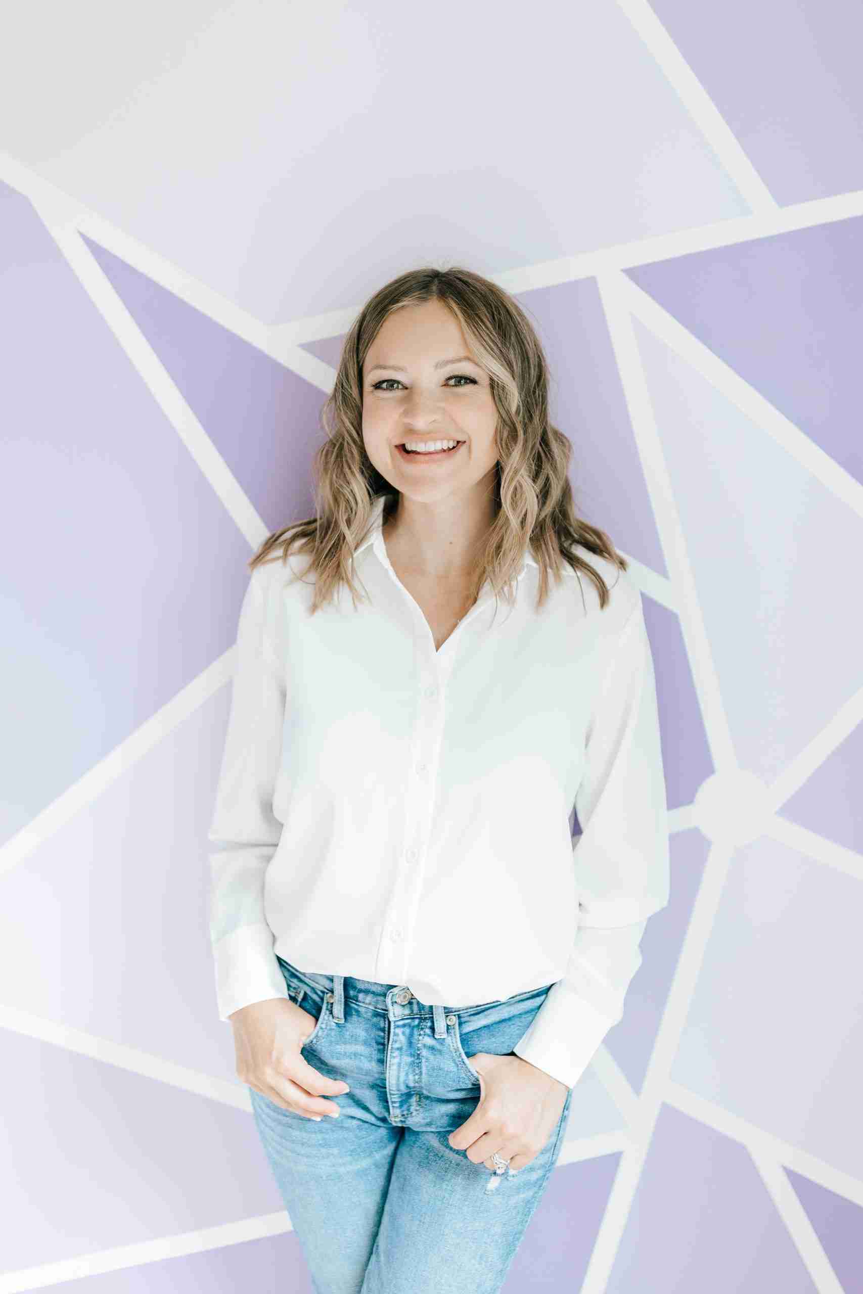 Picture of a casually dressed woman against a geometric background