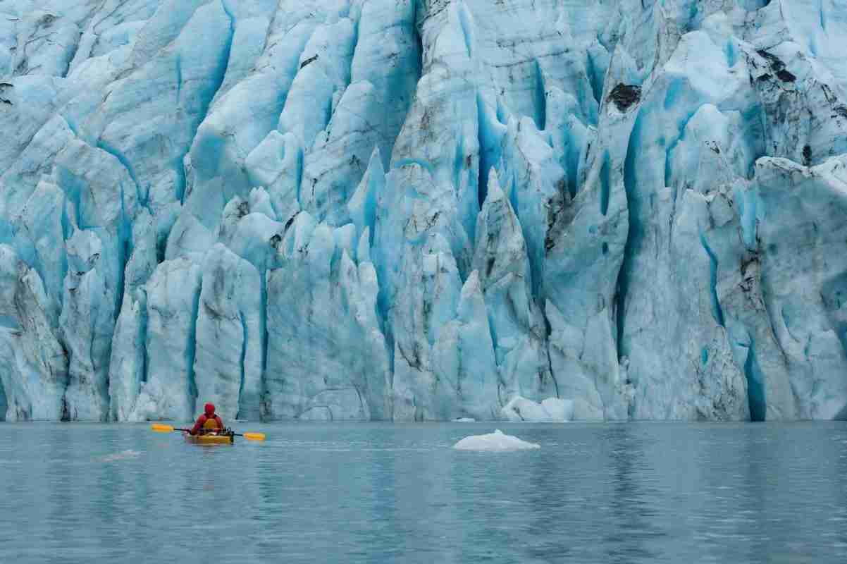 Person kayaking near a glacier